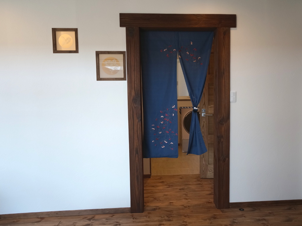 造作アイテム◆お部屋の出入口はあえて扉ではなくアンティークティンバーをあしらい、のれんで空間を間仕切り。壁埋込ガラスも素敵